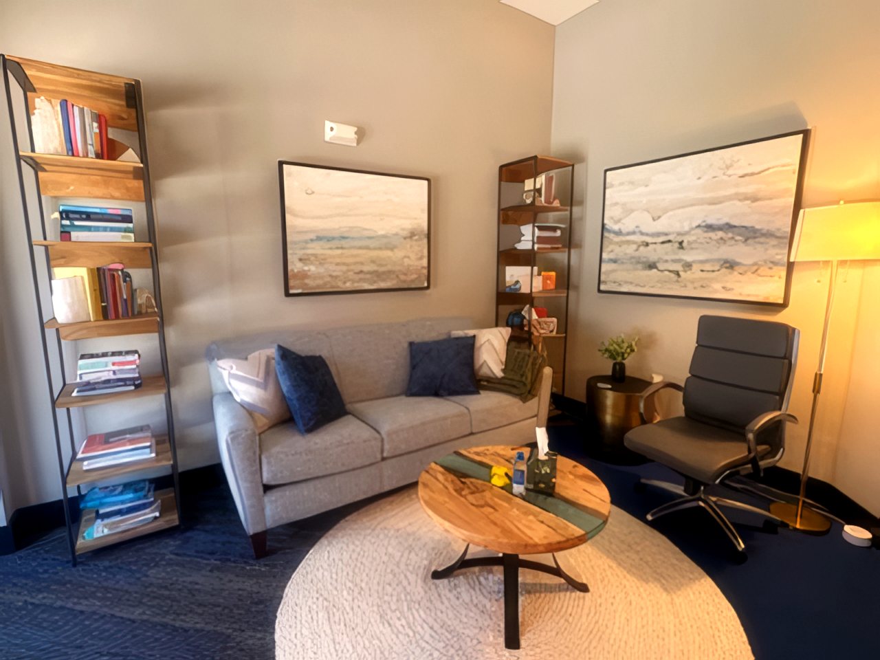 Therapy office at The Art of Becoming Counseling: comfortable couch, bookshelves, and watercolor art